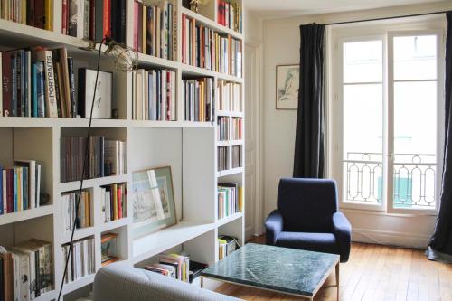 un salon avec une étagère remplie de livres dans l'établissement Nice T2 - near Palais Garnier, à Paris