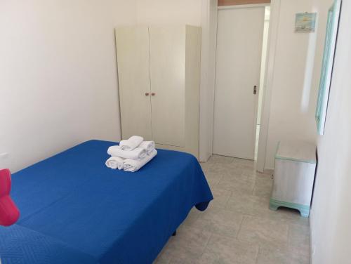 a room with a blue bed with towels on it at casa dolce casa in Patù