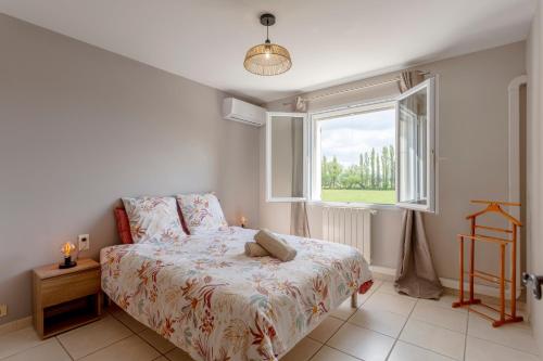 une chambre avec un lit et une fenêtre dans l'établissement L'Estive - Maison climatisée avec piscine, à Tarascon