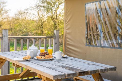 a wooden picnic table with food and drinks on it at Skylark - Sweffling Hall in Rendham
