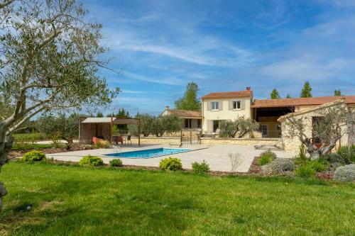 une maison avec une piscine dans une cour dans l'établissement L'Estive - Maison climatisée avec piscine, à Tarascon