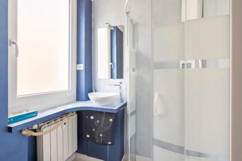 a blue bathroom with a sink and a shower at Blu Marina Alassio in Alassio