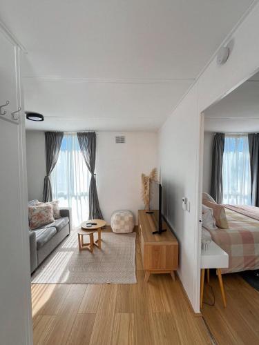 a bedroom with a bed and a living room at Bayside Bungalow in Frankston