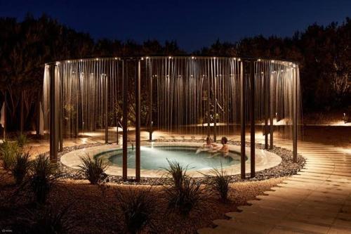 a swimming pool with two people in it at night at Bayside Bungalow in Frankston
