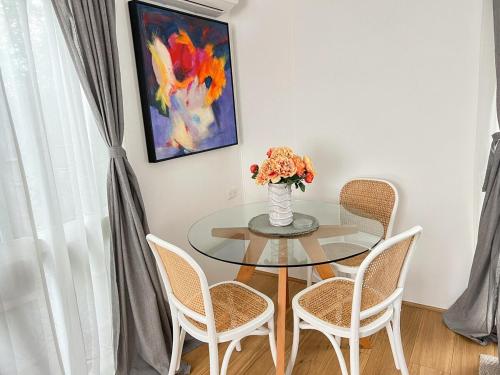 a dining room table with a vase of flowers on it at Bayside Bungalow in Frankston