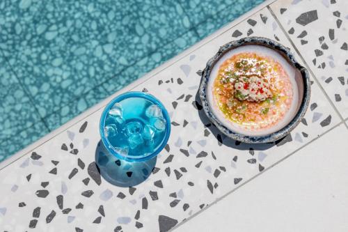 a bowl of food on a table next to a pool at Pearl SeaBreeze Suites in Rethymno Town