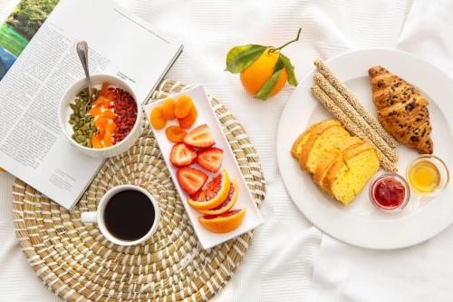 a table with a plate of food and a cup of coffee at Pearl SeaBreeze Suites in Rethymno Town