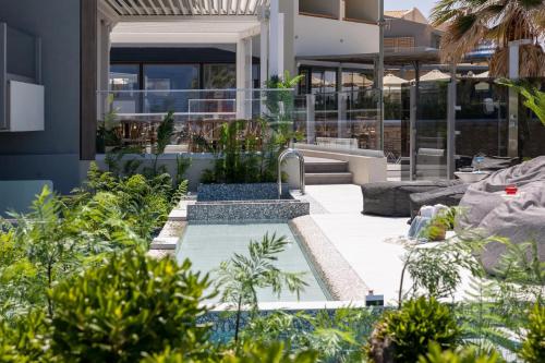 a garden with a pool in front of a building at Pearl SeaBreeze Suites in Rethymno Town