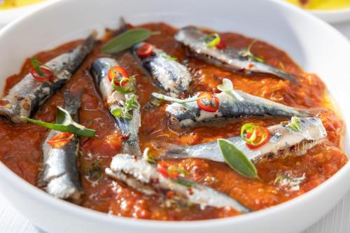 a bowl of food with fish in a sauce at Pearl SeaBreeze Suites in Rethymno Town