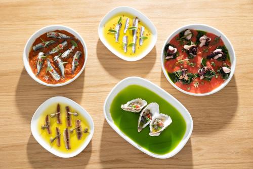 a group of bowls of food on a wooden table at Pearl SeaBreeze Suites in Rethymno Town