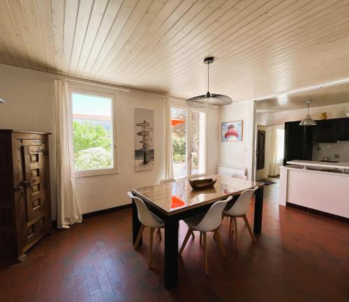 - une cuisine avec une table à manger et des chaises dans l'établissement SALINE maison spacieuse à Le Flotte en Ré, à La Flotte