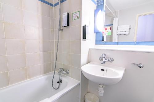 ein Badezimmer mit einem Waschbecken, einem WC und einer Badewanne in der Unterkunft Campanile Manchester in Manchester