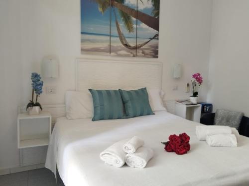 a bedroom with a white bed with towels on it at Hotel Birillo in La Spezia