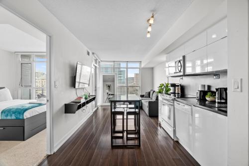 a kitchen and living room with a bed and a room with a kitchen at Apartment in Downtown Toronto in Toronto