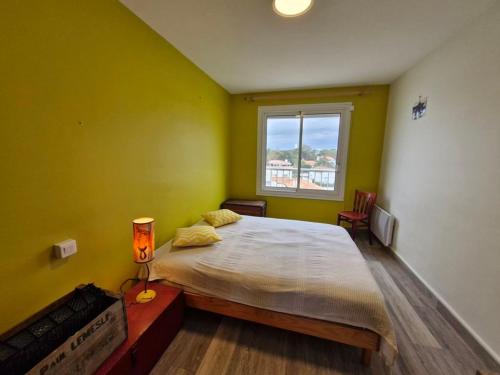 une chambre avec un grand lit et une fenêtre dans l'établissement Grand balcon face mer appartement 2 chambres rénové, à Saint-Jean-de-Monts