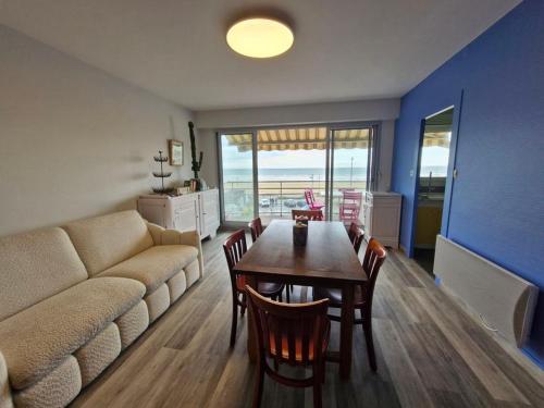 un salon avec un canapé, une table et des chaises dans l'établissement Grand balcon face mer appartement 2 chambres rénové, à Saint-Jean-de-Monts