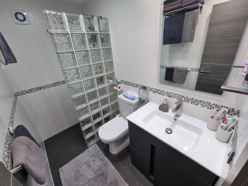 a bathroom with a sink and a toilet and a shower at Cabo Cervera primera linea apartamento de lujo in Torrevieja