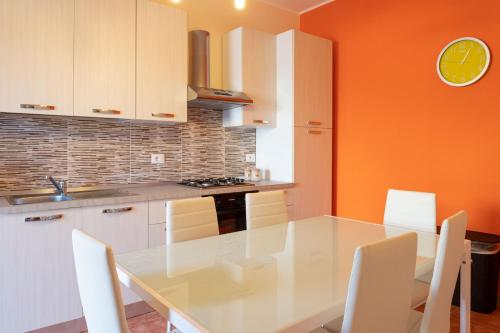 a kitchen with a white table and white chairs at GuestHost - Villa Isidoro Pizzolungo Vibes in Pizzolungo