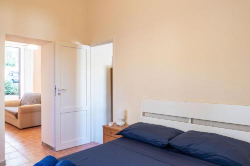 a bedroom with a bed and a chair and a door at GuestHost - Villa Isidoro Pizzolungo Vibes in Pizzolungo