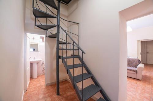 a black spiral staircase in a room with a bathroom at GuestHost - Villa Isidoro Pizzolungo Vibes in Pizzolungo