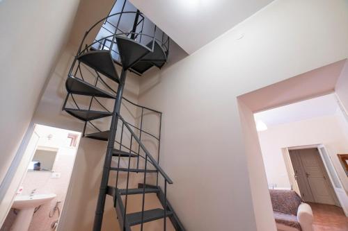 a spiral staircase in a room with a white wall at GuestHost - Villa Isidoro Pizzolungo Vibes in Pizzolungo