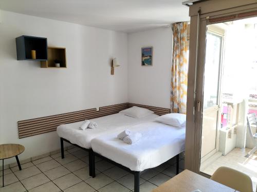 deux lits dans une chambre avec une fenêtre dans l'établissement Résidence Graziella Studio 205, à Juan-les-Pins