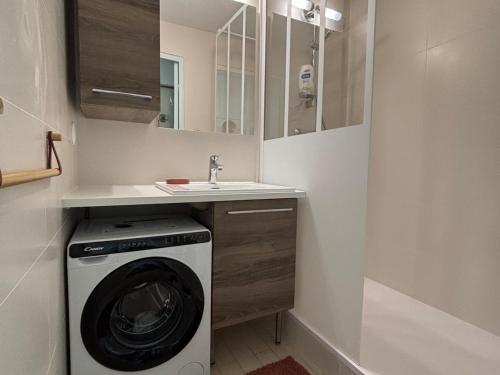 une salle de bain avec une machine à laver et un lavabo dans l'établissement Beau T2 à Sète avec loggia vitrée, vue mer et marina - FR-1-472-131, à Sète