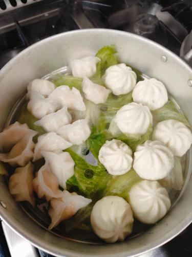 a pot of food with wontons and vegetables in it at HOSTAL DON JAVIER in Ororbia