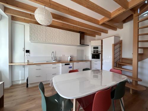 - une cuisine avec une table et des chaises blanches dans l'établissement La Pause Binicaise - Maison proche plage, à Binic
