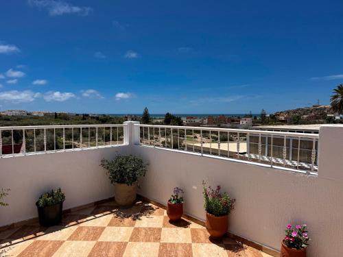a balcony with potted plants and a view at Dar Surfana Morocco in Aourir