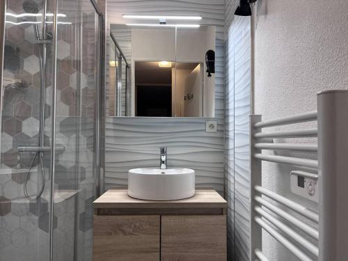 une salle de bain avec un lavabo blanc et une douche dans l'établissement Appartement à Cauterets avec terrasse et parking - FR-1-812-20, à Cauterets