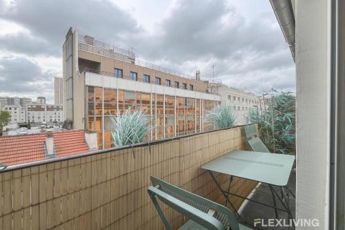 d'une table et d'une chaise sur un balcon avec un bâtiment dans l'établissement Flexliving - Onebedroom - Albert, à Paris