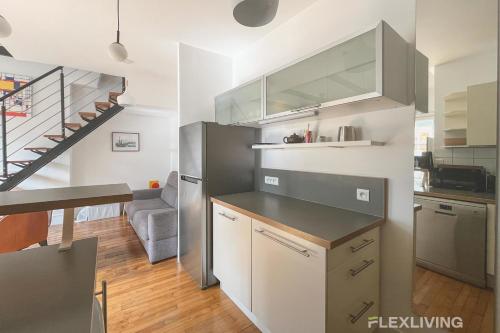 une cuisine avec un réfrigérateur en acier inoxydable et un escalier. dans l'établissement Flexliving - Onebedroom - Albert, à Paris