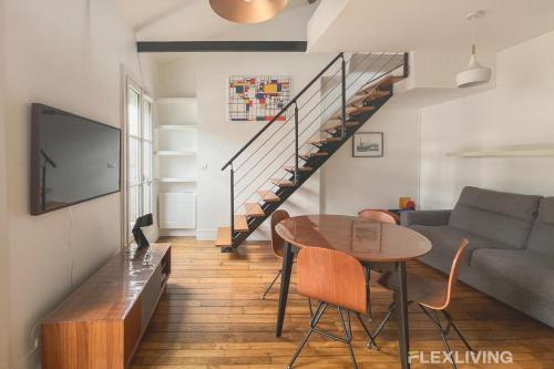 un salon avec une table et un escalier dans l'établissement Flexliving - Onebedroom - Albert, à Paris