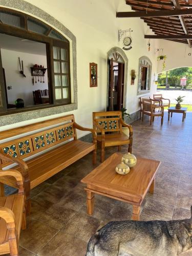 a living room with wooden benches and a table at Sítio Roselaine - Dream Place in Jacareí