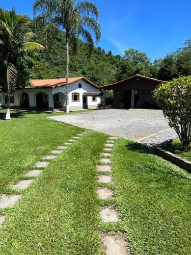 a house with a palm tree and a lawn at Sítio Roselaine - Dream Place in Jacareí