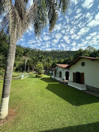 a palm tree in front of a house at Sítio Roselaine - Dream Place in Jacareí