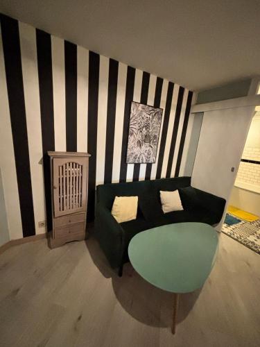 a living room with a couch and a green chair at Kaz Fleuri in Saint-Denis