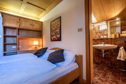a small bedroom with a bed and a sink at Panorama Apartments Walter in Ortisei