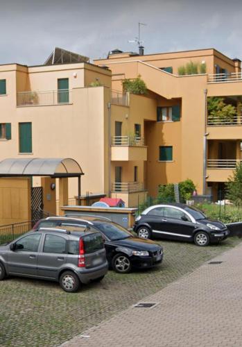 tre auto parcheggiate in un parcheggio di fronte a un edificio di Gloria's GARDENIA RETREAT a Como