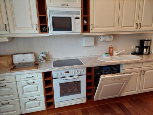 a kitchen with white cabinets and a white stove top oven at Villa Lindenhof in Bad Elster