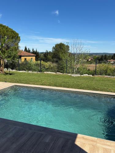 une piscine avec de l'eau bleue dans une cour dans l'établissement Soleil du Sud, à Boisset-et-Gaujac