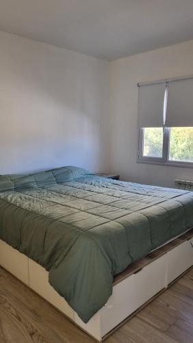 a large bed in a bedroom with a window at Hermoso duplex a 500m del Paseo de la Costa in Neuquén