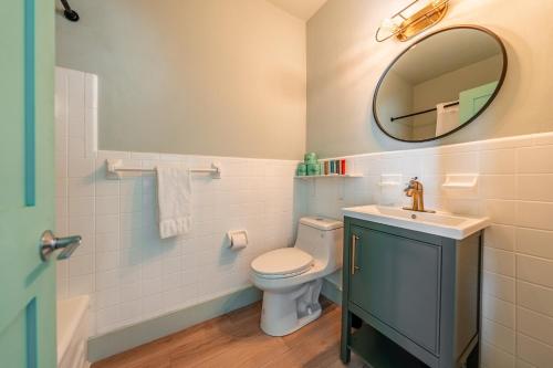 a bathroom with a toilet and a sink and a mirror at Monaco Vacation Rentals in Clearwater Beach