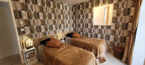 Cette chambre dispose de deux lits et d'un mur. dans l'établissement Le grand clos, 3 étoiles, à Pont-Saint-Martin