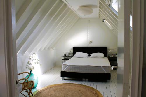 a bedroom with a bed in a white room at B&B de Friese Meren, helemaal privé voor jou! in Tjerkgaast
