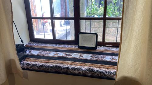 a window with a tablet sitting on a window sill at Casa Cusco Centro in Cusco