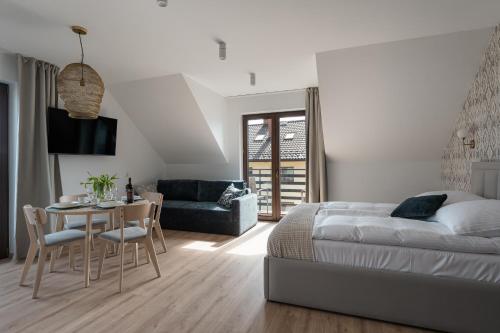 a bedroom with a bed and a table and a couch at Orchidea Willa Pienińska in Sromowce Wyżne
