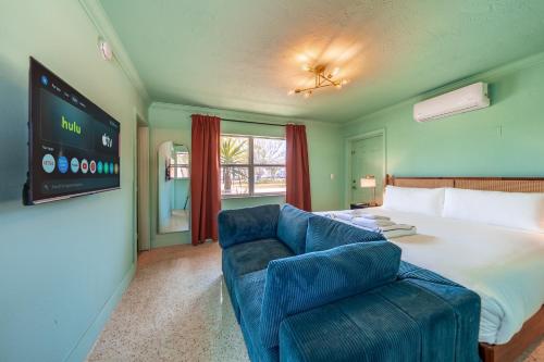 a bedroom with a large bed and a blue couch at Monaco Vacation Rentals in Clearwater Beach