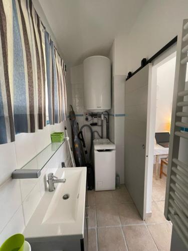 La salle de bains est pourvue d'un lavabo et d'un lavabo blancs. dans l'établissement Maison Les Lavandes 4 people - sea and forest view, à La Croix-Valmer